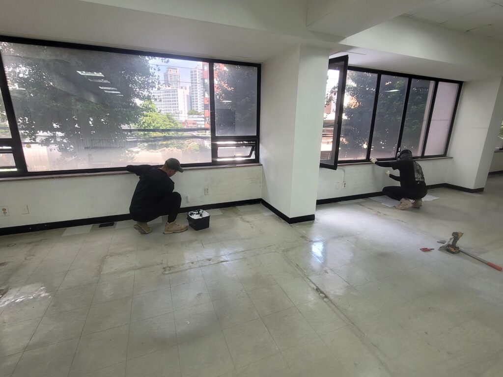 사무실 원상복구를 위해 바닥 타일을 부분 보수하는 작업 모습